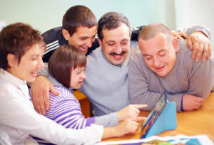 33677207 - group of happy people with disability having fun with tablet